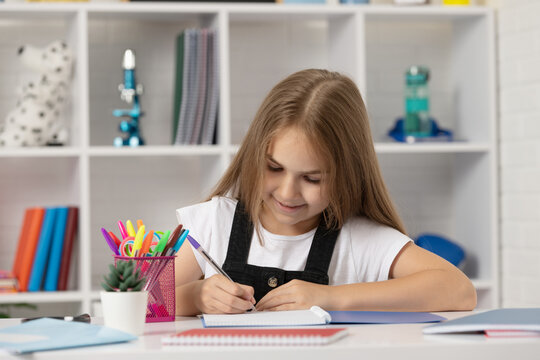 happy kid write in workbook at school lesson in classroom wear uniform, knowledge