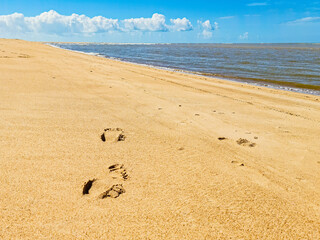 Pegada na areia na praia da Passarela Ecológica do Gigica sobre o manguezal e ao final praia fluvial e de mar aberto. Cidade de Mucuri, no sul da Bahia na região nordeste do Brasil.