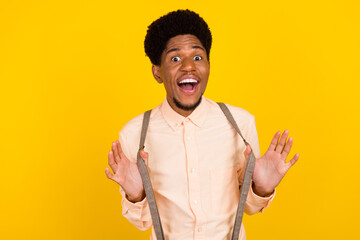 Photo of funky crazy cheerful african guy playful mood wear suspenders shirt isolated yellow color background