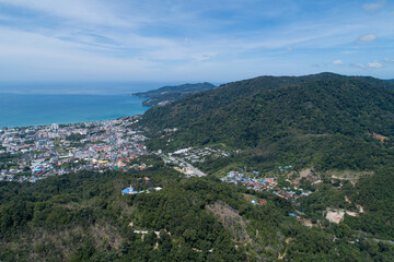 Naklejka na ściany i meble Aerial view blue ocean and blue sky with mountain in the foreground at Patong Bay of Phuket Thailand Landscape of patong city phuket in sunny summer day time Beautiful tropical sea High angle view.