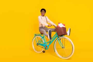 Photo of funny courier geek guy ride bicycle deliver present box wear suspenders shirt isolated...