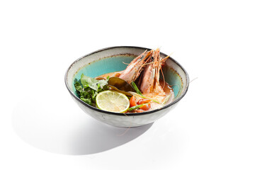 Tom yum or tom yam - hot and sour Thai soup with mixed seafood. Thai traditional soup with shrimps and coconut milk. Tom yum on white background. Isolated soup plate over white background. .