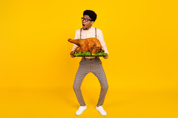 Full length body size photo man amazed funny keeping baked chicken thanksgiving day isolated vivid...