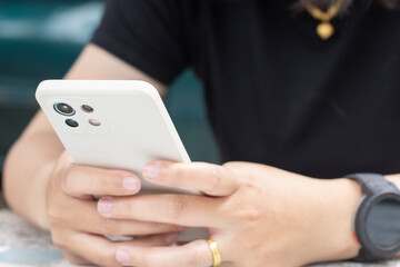 Close up of woman hand holding and using smartphone.