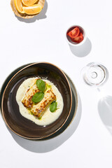 Italian beef cannelloni with bolognese ragu, bechamel sauce and cheese. Baked pasta cannelloni with meat and cheese parmesan. Italian aesthetic white table. Harsh shadow in Italian menu restaurant.