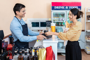 Business Owner. A cheerful successful small business owner standing to welcome. Selling to customers at the counter in coffee shops and convenience stores.