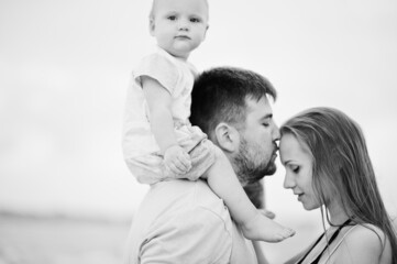 Summer vacations. Parents and people outdoor activity with children. Happy family holidays. Father, pregnant mother, baby daughter on sea sand beach.