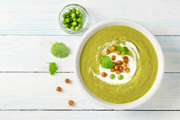 classic split pea soup with roasted chickpeas on wooden background. Top view, copy space.