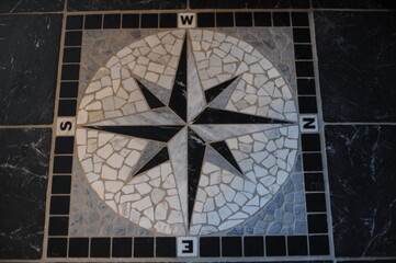 Black and white compass rose, sometimes called a wind rose or rose of the winds made with floor...
