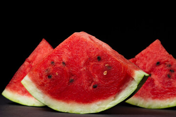 Watermelon on a black background. Isolated slice of watermelon