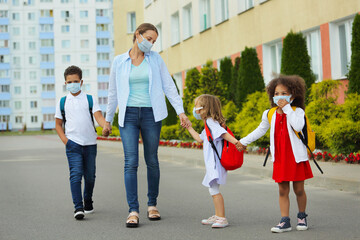 Obraz premium Cute white and black students with adult are going to school. together