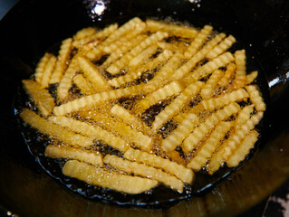 .cooking french fries. Close up of frying french fries in the fryer in hot oil.