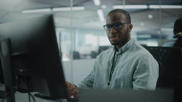 Real Office: Professional Black IT Programmer Working on Desktop Computer. Male Website Developer and Software Engineer Developing App, Video Game. Progressive, Innovative and Inspirational Person