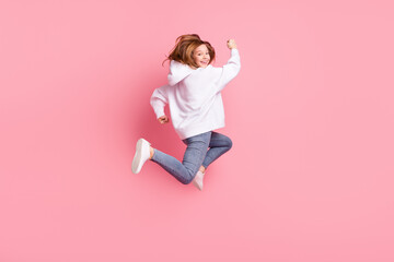 Full length body size view of attractive funky cheerful girl jumping running isolated over pink pastel color background