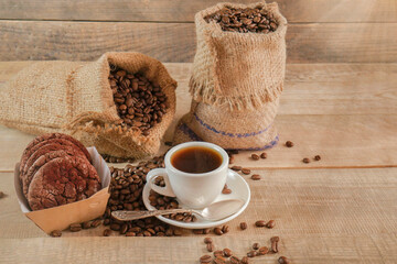 A cup of coffee. A sack of coffee on a wooden background, hot and fresh morning coffee. Copyspace