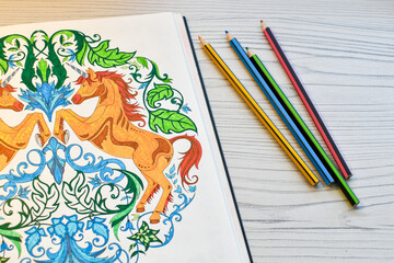 Drawing of a horse in a notebook with colored pencils