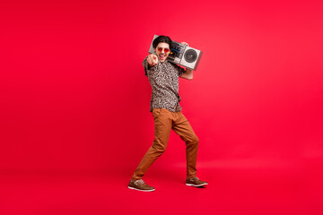 Full size photo of funky funny excited smiling male dancing point finger choose you isolated on red color background