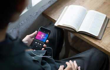 Christian man listen to worship song and praying to GOD with church online Sunday Live Church with the bible.Quarantine from Covid-19 Coronavirus pandemic.