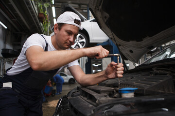 Fototapeta na wymiar Professional mechanic repairing automobile at car service station