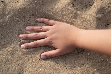 Hand on the beach sand