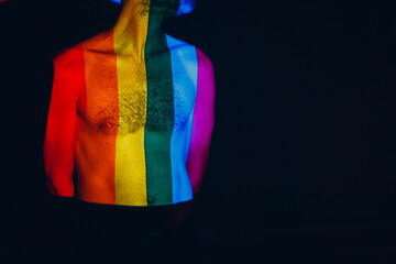 Rainbow Flag on body of adult man in dark