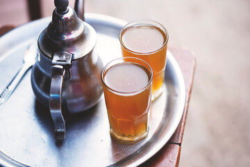 Moroccan tea, kettle and glass of fresh tea, Essaouira, Morocco