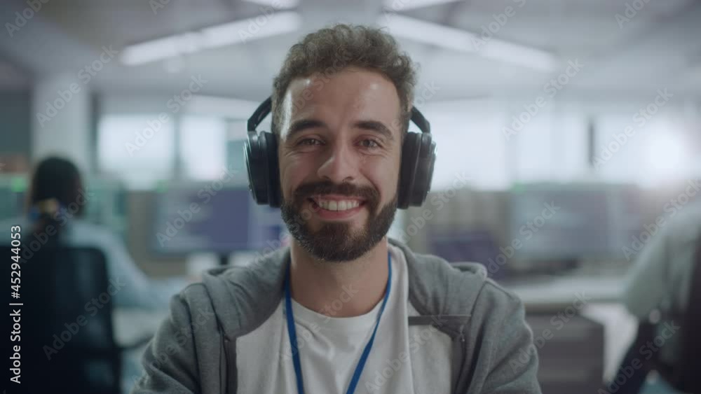 Aufkleber Office: Portrait of Happy IT Programmer Wearing Headphones Working on Desktop Computer, Looking at Camera and Smiling. Male Software Engineer Developing App, Video Game. Listening to Podcast, Music