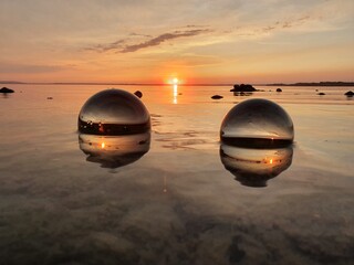 Fototapeta na wymiar Sonnenuntergang mit Glaskugeln im See