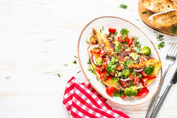 Omelet with fresh vegetables - broccoli, tomatoes and paprika. Healthy breakfast. Top view with copy space.