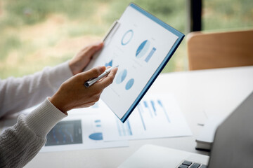 Financial Businesswomen analyze the graph of the company's performance to create profits and growth, Market research reports and income statistics, Financial and Accounting concept.