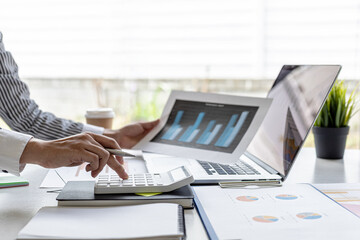 Businessman working in a private office, she is reviewing the company's financial documents sent...