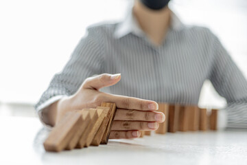 Women put their hands between wooden blocks, wooden blocks arranged in dominoes, likened to running...