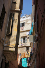 Narrow street of the Old Medina; air-drying clothes in the sun, a piece of the sky between houses. Casablanca, Morocco.