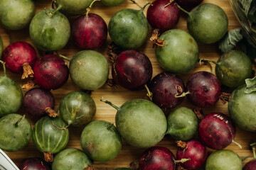 Green and red gooseberries. Gooseberries on a wooden surface