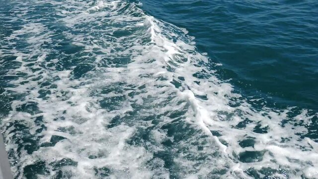 Water foam trace behind sailing ship. Fast moving motor boat in sea, view of yacht trail behind. Rear view of motor speed boat with Water wake foam trace behind the engine. 4 k video
