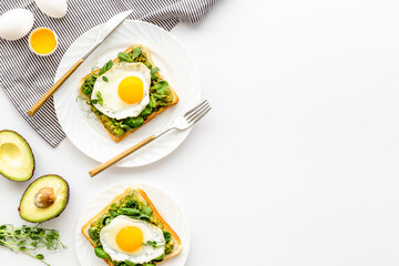 Eggs and avocado with spinach on toasted bread. Top view
