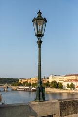 Single street lamp on a bridge with flowing water at sunset.