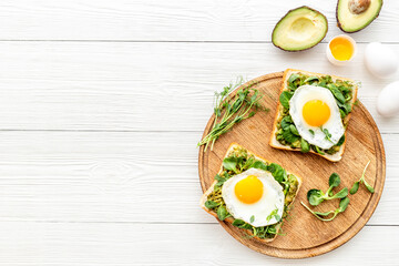 Breakfast with toasts of fried eggs and avocado saurce. Top view