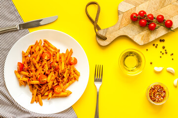 Cooked italian pasta in plate with tomato sauce and herbs