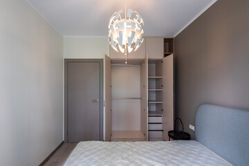 Modern interior. Bedroom in apartment. Beige wall. New mattress on bed