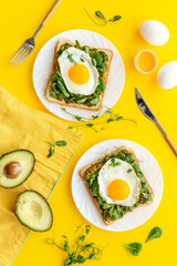 Eggs and avocado with spinach on toasted bread. Top view