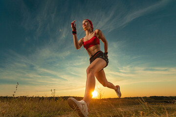 Sprinter run. Strong athletic woman running on black background wearing in the sportswear. Fitness...