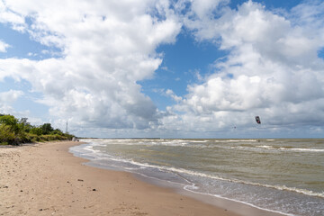 empty sandy beach and single kite surfer in the Baltic Sea near Pavilosta in Latvia