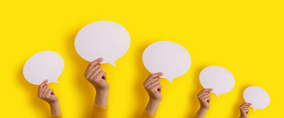 speech bubbles in hand over yellow background, panoramic layout over dialogue icon