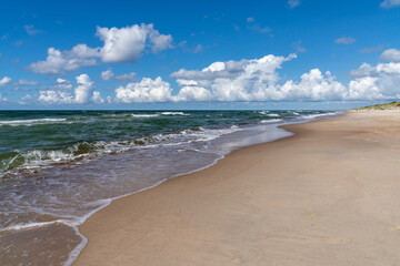 Fototapeta na wymiar beautiful idyllic endless white sand beach with a calm ocean and gentle waves and sand dunes