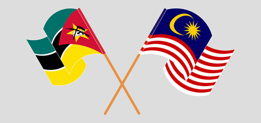 Crossed and waving flags of Mozambique and Malaysia