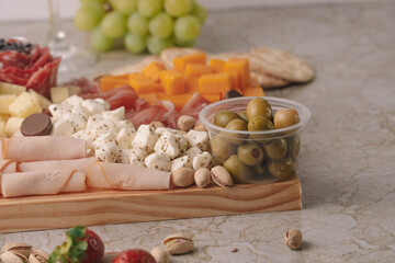 olives detail on a chesee platter on a marble table
