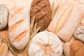 Bread, pastries on a light wooden background. Bread with sesame seeds and seeds, bread texture. Delicious flavored bun. Lots of airy fresh bread.