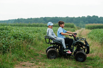 Two brothers driving four-wheller ATV quad bike. Happy children moments. © AS Photo Family