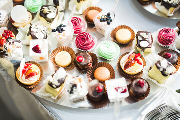 Delicious and tasty dessert table with cupcakes shots at reception closeup